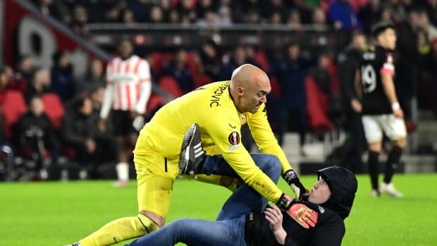 El portero del Sevilla Marko Dmitrovic defendiéndose de la agresión de un hooligan del PSV